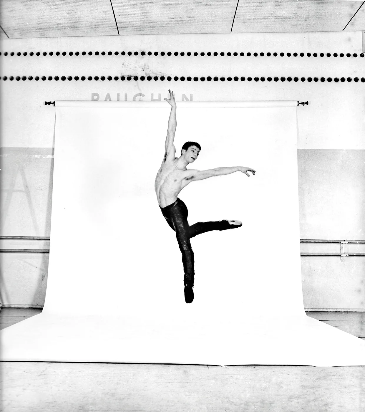 Alexandre Munz danseur, en suspension dans un studio de répétition — photographie en noir et blanc.